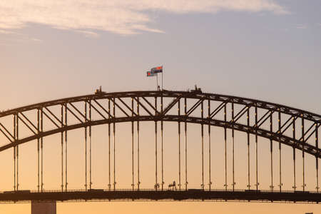 Sydney Harbour Bridge with warm sunset sky.