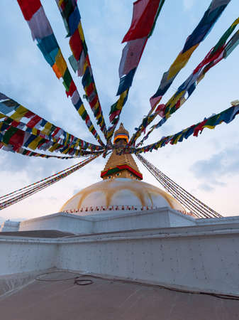 Kathmandu, Nepal - December 7, 2018: Dusk view of Boudhanath Stupa with flags around the corner.のeditorial素材
