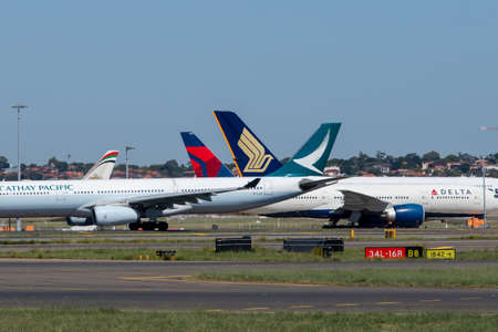 Sydney, Australia - February 12, 2019: Tail of Delta, Singapore Airlines, and Cathay Pacific aircraft at Kingsford Smith Sydney International Airport.のeditorial素材