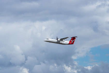 Sydney, Australia - March 20, 2019: Qantas Bombardier Dash 8 flying on a cloudy bright sky.のeditorial素材