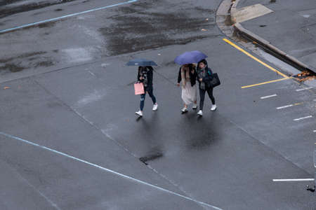 Adelaide, Australia - May 11, 2019: Tree women walking on the street with umbrellaのeditorial素材