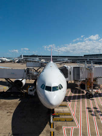 Sydney, Australia - September 28, 2019: Qantas Airbus A330 under the baggage loading and connected to aerobridge at Sydney International Airport.のeditorial素材