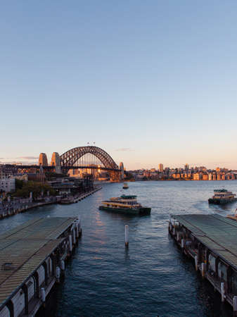 Sydney, Australia - November 10, 2019: Circular Quay ferry wharf and Sydney Harbour Bridge view during sunset.のeditorial素材
