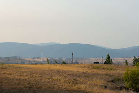 Grass field and layer of mountains.