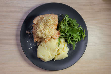 A plate of salmon, rocket salad, and mashed potato.の写真素材