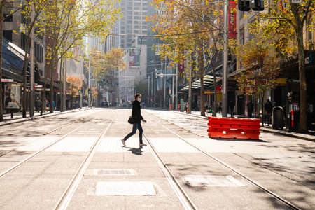 Sydney, Australia - June 13, 2020: A person with mask crossing George St.のeditorial素材