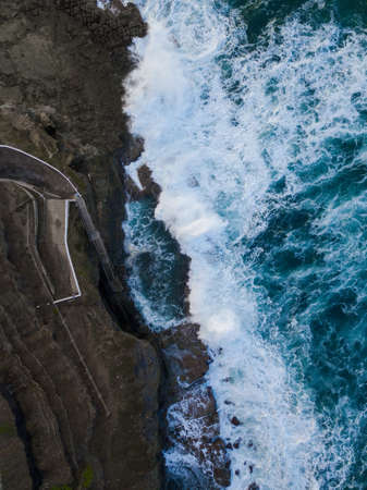 Wave crashing into Bogey Hole rock pool, Newcastle, Australia.