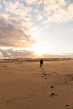 Stockton, Australia - July 30, 2020: A person walking alone in the desert.のeditorial素材
