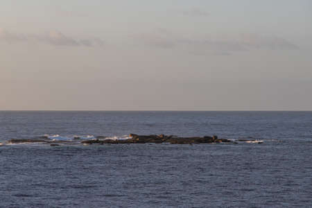 An island of rock in the middle of the ocean.