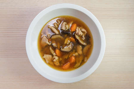 A bowl of chicken, carrot, and mushroom stew.