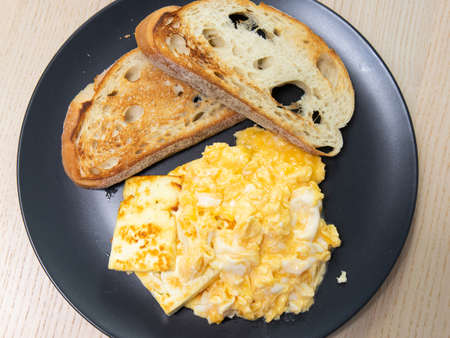 A plate of bread, scrambled eggs, and haloumi cheese.の写真素材