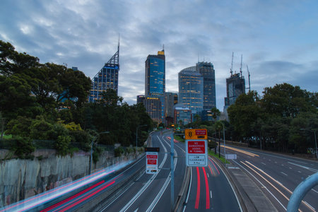 Sydney, Australia - December 30, 2020: Car travelling on the highway with city skyline on the background.のeditorial素材