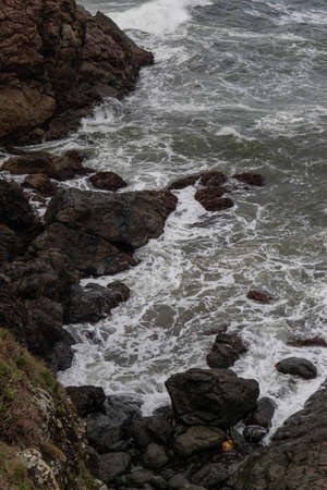 Rocky seascape view with waves around it.