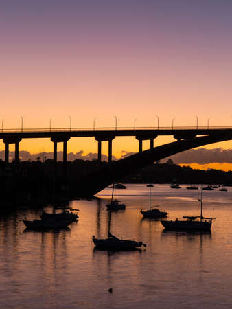Sydney, Australia - April 13, 2021: Boat and Gladesville Bridge silhouette.のeditorial素材