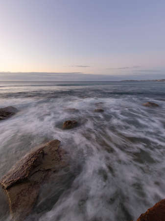 Flowing wave water on the beach during high tide.
