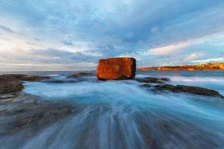 High tide sunrise flow around North Bondi rocks.の写真素材