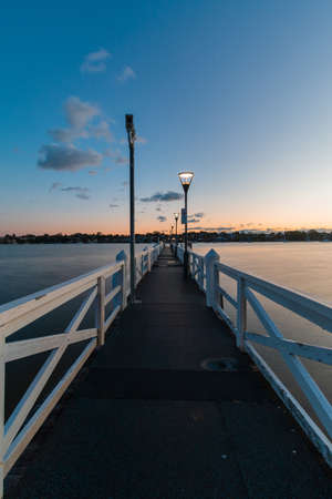 An empty jetty into the water edge at sunrise time.の写真素材