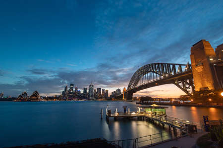 Sydney, Australia - January 1, 2022: Ferry wharf and Sydney Harbour Bridge view at dusk.のeditorial素材