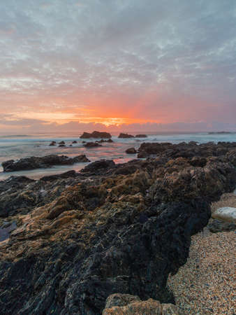 Beautiful sunrise view by the rocky coastline.の写真素材