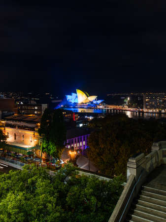 Sydney, Australia - March 3, 2022: Sydney Opera House view at night. Opera House lights up with...