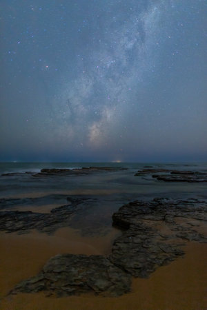 Milky way galaxy over the rocky coastline.の写真素材
