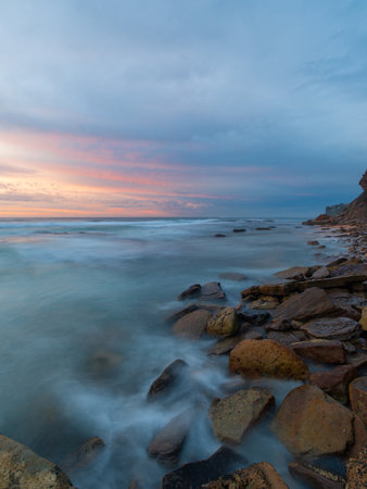 Sunrise view of rocky coastline with beautiful sky.の写真素材