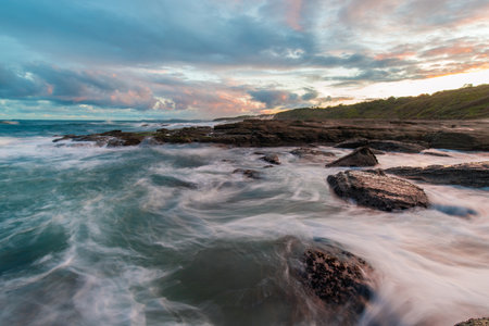 Water flowing between rocks on the coastline.の写真素材