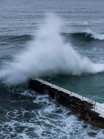 Sydney, Australia - February 27, 2022: Wave crashing into the edge of Bondi Icerbergs pool.のeditorial素材