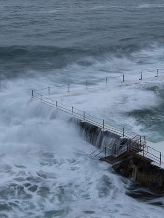 Sydney, Australia - February 27, 2022: High tide ocean water flowing into Bondi Icerbergs pool.のeditorial素材