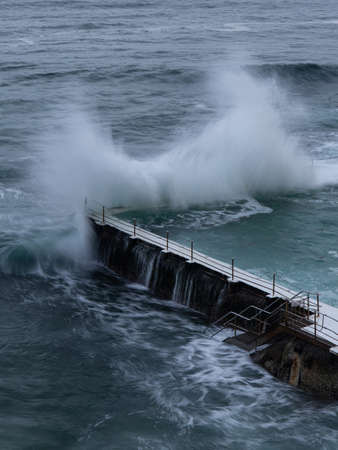 Sydney, Australia - February 27, 2022: Wave crashing into the edge of Bondi Icerbergs pool.のeditorial素材