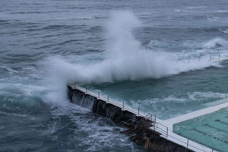 Sydney, Australia - February 27, 2022: Wave crashing into the edge of Bondi Icerbergs pool.のeditorial素材