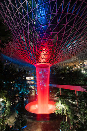 Singapore - May 19, 2022: Jewel Changi Airpot vortex waterfall in red.のeditorial素材