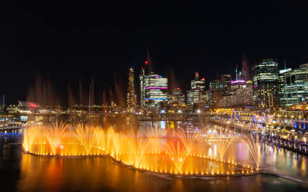 Sydney, Australia - June 8, 2022: Orange colored fountain show at Darling Harbour for Vivid Sydney.のeditorial素材