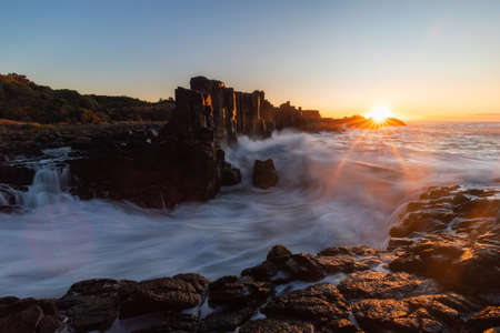 Sunrise view with breaking wave at Bombo Quarry, Australia.の写真素材