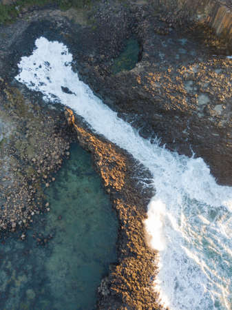 Top down view of wave water between rock channel.の写真素材