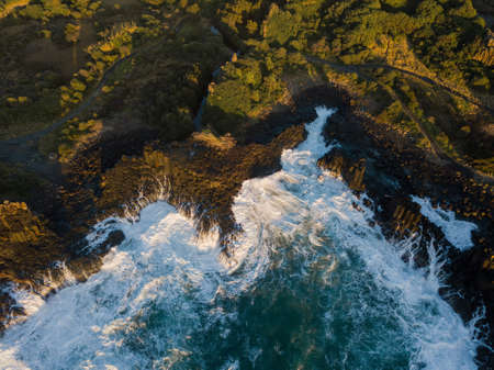 Rough ocean water around the rocky coastline.の写真素材