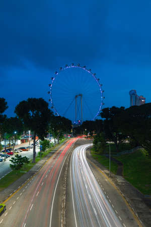 Singapore - May 23, 2022: Car trails around Singapore Flyer at night.のeditorial素材