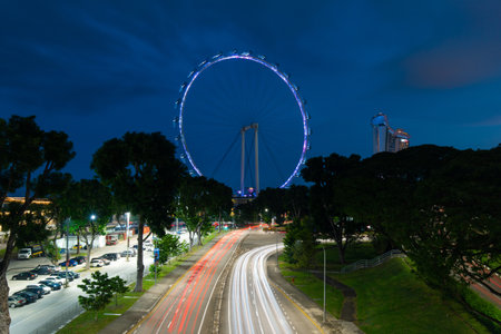 Singapore - May 23, 2022: Car trails around Singapore Flyer at night.のeditorial素材