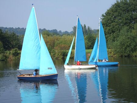 A Collection of Sailing Dinghies on a River.