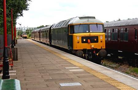 A Vintage Diesel Engine Train Arriving at a Station の写真素材