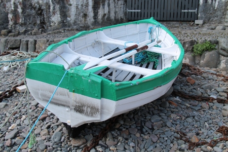 A Moored Rowing Boat on a Dry Stony Harbour Floor.の写真素材