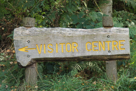 A Rustic Wooden Sign Pointing to a Visitor Centre の写真素材