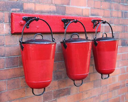 Three Wall Mounted Red Metal Fire Sand Buckets.の写真素材