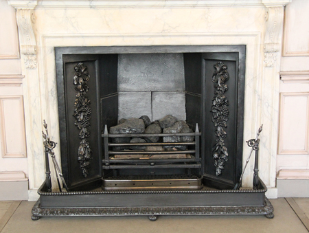 A Vintage Cast Iron Fireplace with a Black Metal Fender.の写真素材