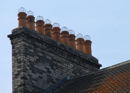 A Set of Nine Terracotta Chimney Pots with Mesh Tops.の写真素材