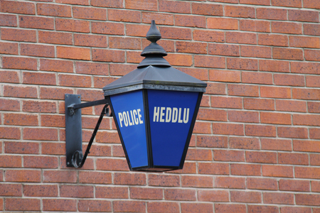 An Outdoor Blue Sign at a Welsh Police Station.の写真素材
