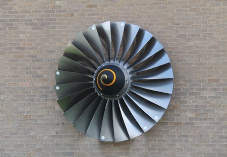 The Blades from a Jet Engine Displayed on a Brick Wall.