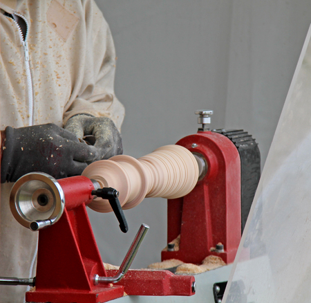 A Carpenter Turning a Piece of Wood on a Small Lathe.の写真素材