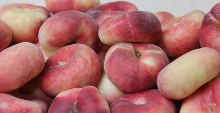 A Collection of Fresh Flat Donut Fruit Peaches.の写真素材