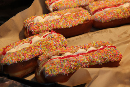 A Display of Fresh Cream Filled Doughnuts with Sprinkles.